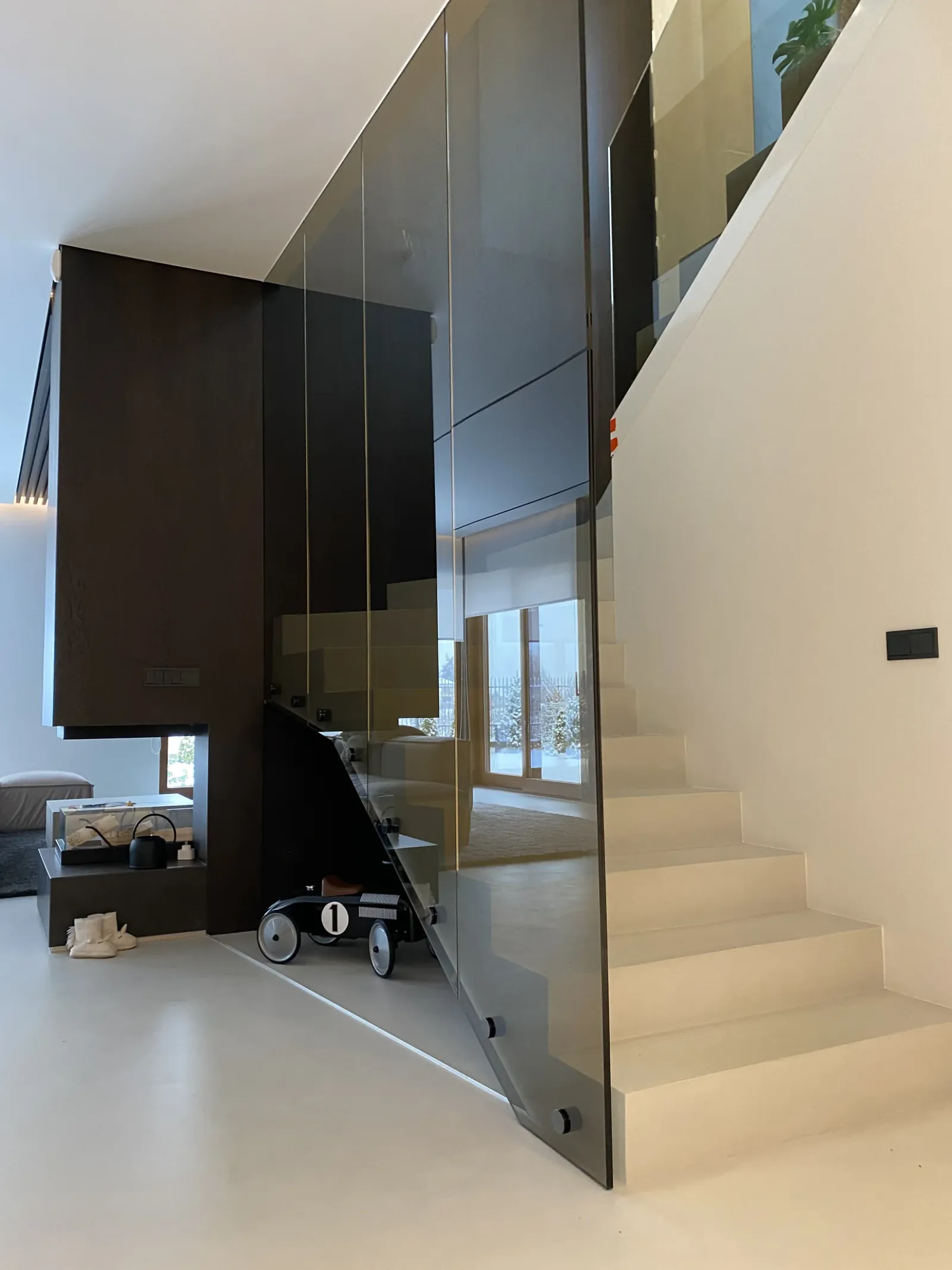 Nowoczesne jasne wnętrze ze szklaną balustradą przy schodach