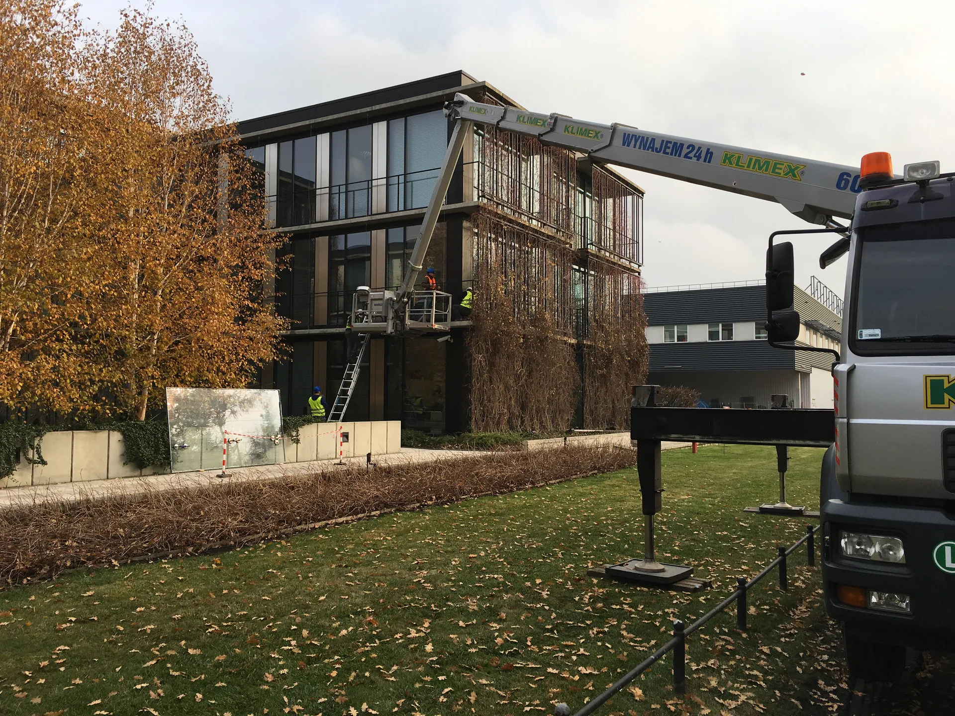 Podnośnik koszowy podczas serwisu szyb fasadowych biurowca