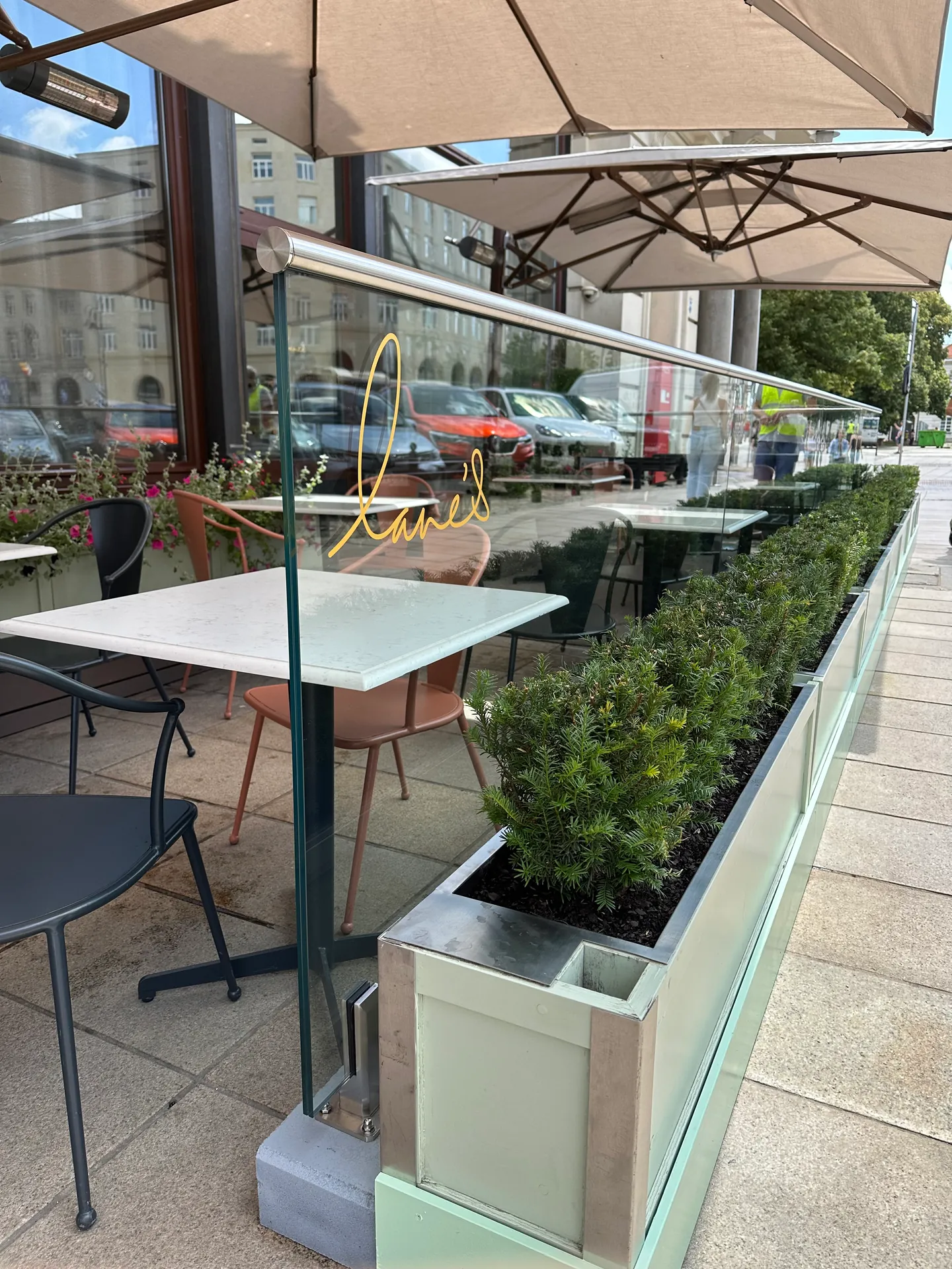 Przezroczysta balustrada przy stolikach w ogródku restauracyjnym